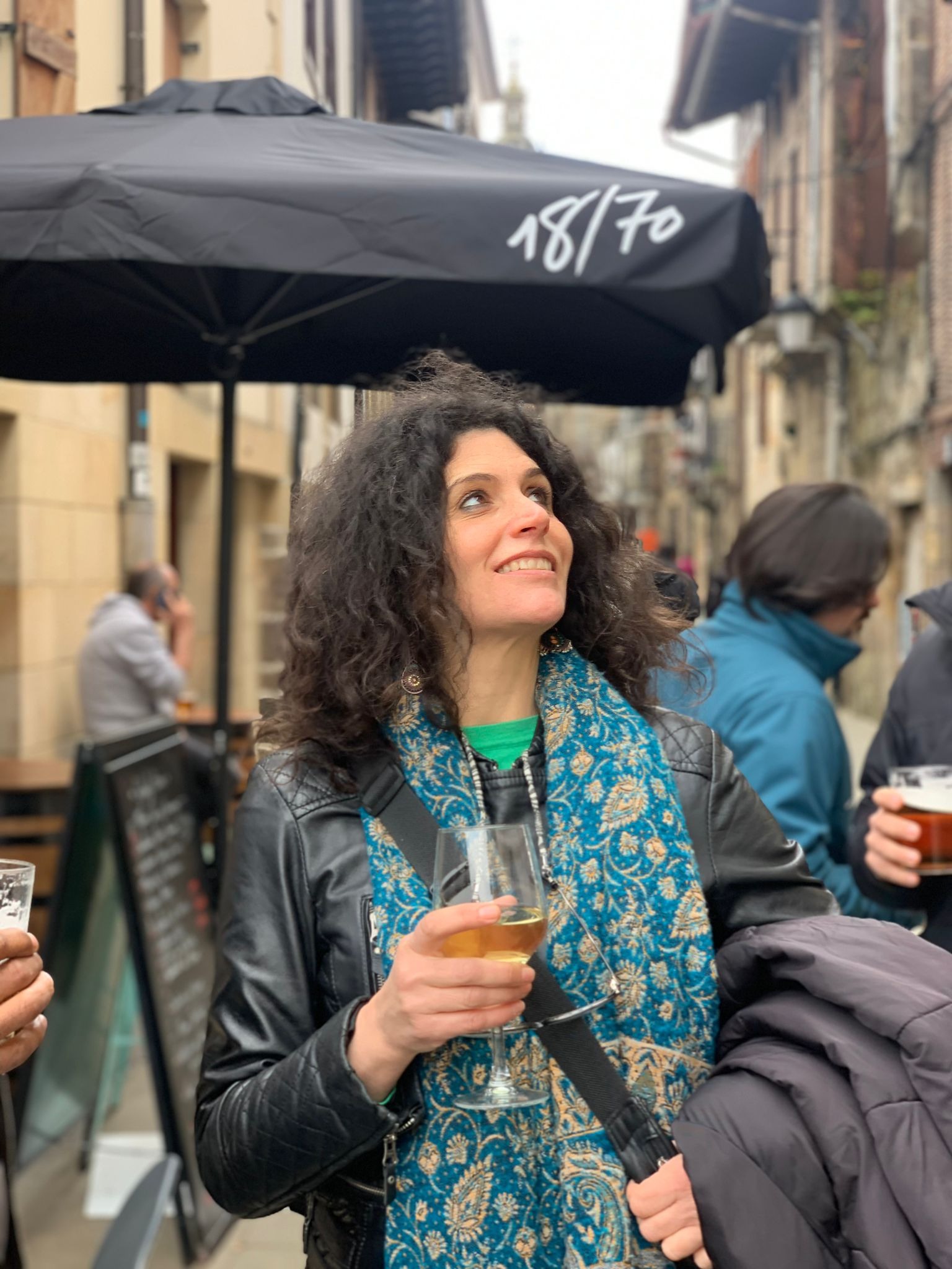 Nora enjoying a drink on a lively street